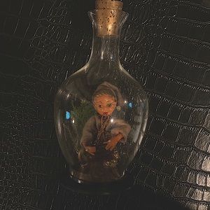 This is a vintage mid century golden pixie elf Playing a harp in a bell jar.